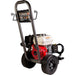 A portable pressure washer with a red and beige gasoline engine, black wheels, and a dark gray metal handle frame, shown on a plain white background.